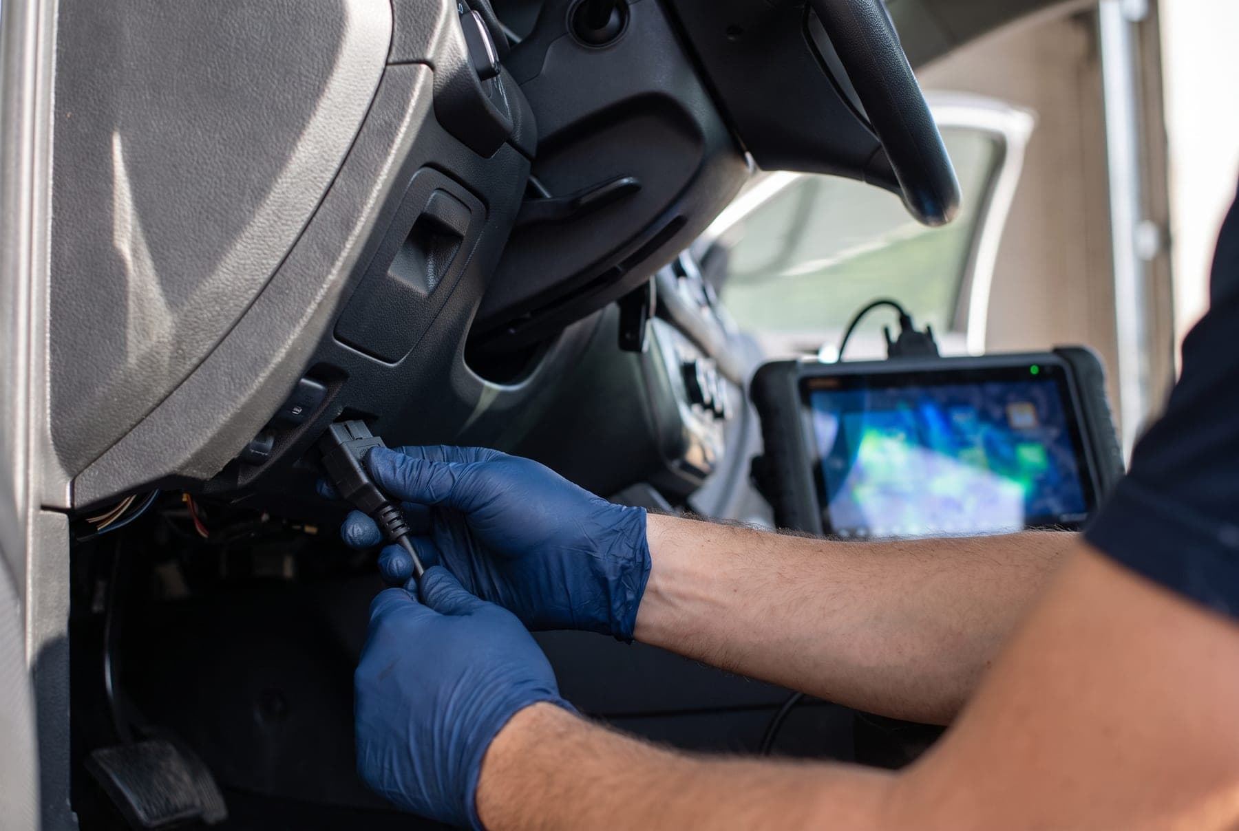 Diagnosestecker wird an der Fahrzeugelektronik angeschlossen.